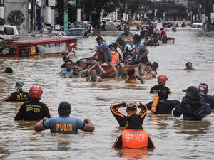 Rescuers pull a rubber boat carrying residents through a flooded street after Typhoon Vamco hit in Marikina City, suburban Manila on November 12, 2020. Ted ALJIBE / AFP