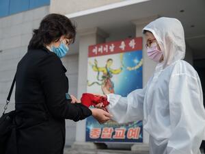 An audience member undergoes a health check as part of preventative measures against the Covid-19 coronavirus, before a performance by the North Korea's National Acrobatic Troupe at the Pyongyang Circus Theater as part of celebrations marking the annual Mother's Day public holiday, in Pyongyang on November 16, 2020. KIM Won Jin / AFP