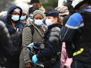 Migrants wait to be evacuated by French police at a makeshift camp set below the A1 highway in the north of Paris' popular suburb of Saint-Denis on November 17, 2020. The police will dismantle the migrant camp at the end of an evacuation operation denounced by associations as an "endless and destructive cycle". Christophe ARCHAMBAULT / AFP