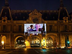 This picture taken early on November 19, 2020, shows a projection on the Louvre Museum in Paris by Amnesty International members depicting French President Emmanuel Macron greeting Saudi Crown Prince Mohammed bin Salman and reading "Stop hypocrisy", ahead of the upcoming virtual G20 summit. THOMAS COEX / AFP