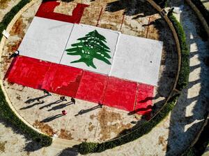 This picture taken on November 21, 2020 shows an aerial view of a partially-completed 300-square-metre Lebanese national flag made up from plastic bottles, caps, and empty bullet cartridge set up by environmental activists at an open-air restaurant and wedding venue in the town of Bnachii in northern Lebanon, a day ahead of the country's 77th independence day. Ibrahim Chalhoub / AFP