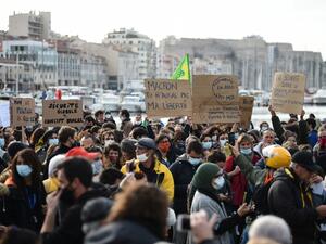 A demonstrator holds a sign reading "Macron, you won't get my freedom" during a rally on the Vieux-Port, called by the "Yellow Vests" movement (Gilets Jaunes) to protest against the "global security" draft law seeking to limit filming of police officers on duty, in Marseille, on November 21, 2020. CLEMENT MAHOUDEAU / AFP