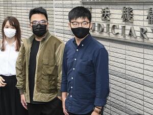 Pro-democracy activists (L-R) Agnes Chow, Ivan Lam and Joshua Wong arrive for their trial at West Kowloon Magistrates Court in Hong Kong on November 23, 2020, on unauthorised assembly charges in relation to protests in 2019. Peter PARKS / AFP