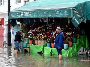 A file picture shows a flower shop owner stranded in a street flooded by torrential rains in the Tunisian capital Tunis. (AFP)