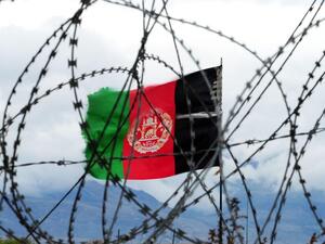 Afghan flag behind barbed wire. (AFP)