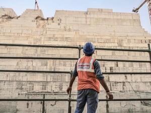 Construction worker eyes progress on the Grand Ethiopian Renaissance Dam in Ethiopia last December (AFP)