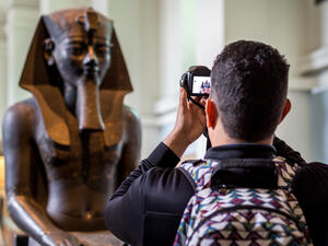 A tourist taking photo of an egyptian status brought from Egypt and kept in British Museum of London. (Shutterstock/ File Photo)