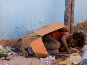 A youth of Yemen's minority group known as "Muhamasheen", which translates to marginalised, plays inside a discarded cardboard box in the capital Sanaa, on October 24, 2020. Mohammed HUWAIS / AFP