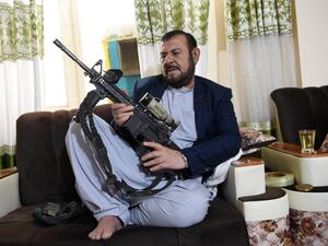 In this photo taken on September 28, 2020, former police chief of the Panjwai district, Sultan Mohammad Hakimi, poses with a gun during an interview with AFP in Panjwai. Despite the bloodshed he has witnessed throughout his career, Hakimi has made it a personal mission to give ex-Taliban fighters, commanders and officials the chance to reintegrate into village life. WAKIL KOHSAR / AFP
