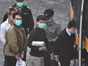 Activists Joshua Wong (C) and Ivan Lam (L) board a police van at Lai Chi Kok Reception Centre in Hong Kong on December 2, 2020, before going to court to be sentenced over a protest which took place outside the police headquarters in 2019. Anthony WALLACE / AFP