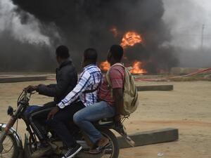 A taxi motorcyclist, popularly called Okada, drives past a tanker laden with petrol that is on fire after it fell over and spilt the contents across the Lagos-Ibadan expressway in Magboro, Ogun State, on December 2, 2020.PIUS UTOMI EKPEI / AFP