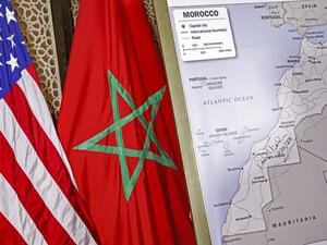 This file photo taken on December 12, 2020 shows (L to R) US and Moroccan flags next to a US State Department-authorised map of Morocco recognising the internationally-disputed territory of the Western Sahara (bearing a signature by US Ambassador to Morocco David T. Fischer) as a part of the North African kingdom, in Morocco's capital Rabat. US President Donald Trump's surprise backing of Morocco's claim to sovereignty over disputed Western Sahara upended years of international consensus, but will this brea