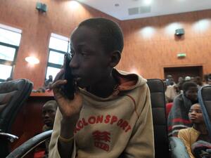 A child speaks on the phone while gathering at the Government House with other students from the Government Science Secondary school, in Kankara, in northwestern Katsina State, Nigeria upon their release on December 18, 2020. More than 300 Nigerian schoolboys were released on Thursday after being abducted in an attack claimed by Boko Haram, officials said, although it was unclear if any more remained with their captors Kola SULAIMON / AFP