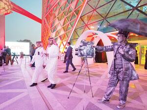 A handout picture provided by the Saudi Royal Palace on April 18, 2018, shows a mime actor standing behind a model vintage cinema camera at the entrance of the AMC cinema in the capital Riyadh ahead of the first test film screening in over three decades. AFP