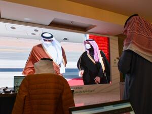 Journalists watch, Saudi Crown Prince Mohammed bin Salman (C-R) welcomes the Emir of Qatar Tamim bin Hamad Al-Thani (C-L), on a screen in the media centre ahead of the 41st Gulf Cooperation Council (GCC) summit in the city of al-Ula in northwestern Saudi Arabia on January 5, 2021. FAYEZ NURELDINE / AFP