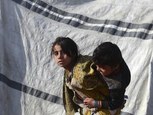 Children play next to a tent at a camp for internally displaced families in Dand district of Kandahar province on January 7, 2021. About 17,000 Afghan families from the Taliban bastion of Kandahar have fled their homes following months of heavy fighting between the insurgents and government forces despite peace talks, officials said  Javed TANVEER / AFP