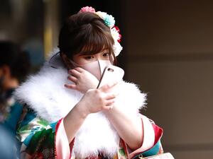 A twenty-year-old woman dressed in a kimono waits at the entrance of Todoroki Arena to attend the "Coming-of-Age Day" celebration ceremony in Kawasaki, Kanagawa prefecture on January 11, 2021 under a state of emergency over the Covid-19 coronavirus pandemic. Behrouz MEHRI / AFP