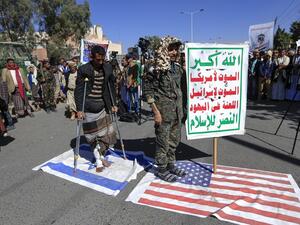Supporters of Yemen's Huthi movement tread on US ans Israeli flags during a demonstration in front of the closed US embassy in the capital Sanaa on January 18, 2021, to reject the outgoing US administration's decision to designate the Huthis a "foreign terrorist organisation". Impoverished Yemen is mired in a devastating conflict between Iran-backed Huthi rebels and government forces backed by Saudi Arabia that has left tens of thousands dead and sparked a dire humanitarian crisis. Mohammed HUWAIS / AFP