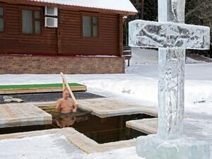 Russian President Vladimir Putin crosses himself as he plunges into the icy waters during the celebration of the Epiphany holiday in Moscow region on January 19, 2021.