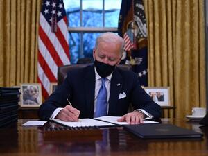 US President Joe Biden sits in the Oval Office as he signs a series of orders at the White House in Washington, DC, after being sworn in at the US Capitol on January 20, 2021. US President Joe Biden signed a raft of executive orders to launch his administration, including a decision to rejoin the Paris climate accord. The orders were aimed at reversing decisions by his predecessor, reversing the process of leaving the World Health Organization, ending the ban on entries from mostly Muslim-majority countries