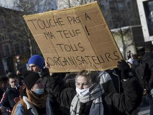 A protestor holds a placard reading "Don't touch my party! All organizers " during a demonstration to support organizers of an illegal New Year rave that saw 2,400 people defy virus rules in Rennes, western France, on January 23, 2021. The wildcat rave party over the New Year in the Brittany region in northwestern France shocked the country as people continue to observe strict bans on gatherings to battle the coronavirus. Sebastien SALOM-GOMIS / AFP
