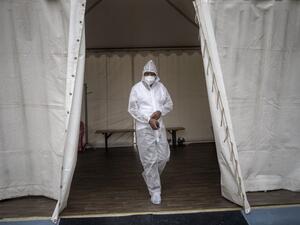 A healthcare worker wearing personal protective equipment (PPE) makes his way out of a temporary ward dedicated to the treatment of possible COVID-19 coronavirus patients at the Nasrec Field Hospital in Soweto, on January 25, 2021. Michele Spatari / AFP