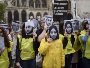 People hold pictures of Samar Badawi (C) and her brother jailed Saudi blogger Raif Badawi (R) as they demonstrate in support of Raif Badawi, who was sentenced to 1,000 lashes for insulting Islam, on May 7, 2015 in Paris. (AFP / Stephane De Sakutin)