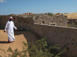 A former inhabitant of Wadi al-Murr, walks near an abandoned house in the Omani village, about 400 kms south-west of the capital Muscat. (AFP)