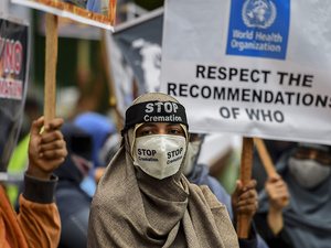 Protesters hold placards during a demonstration against the government policy of forced cremations of Muslims who died of the Covid-19 coronavirus, outside a cemetery in Colombo. (AFP)