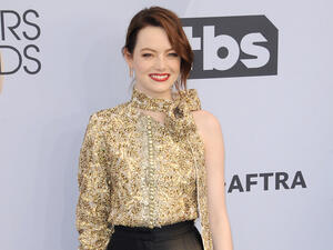 Emma Stone has been spotted cradling her burgeoning belly while out on a walk in Los Angeles. 