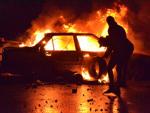 Lebanese protesters burn a vehicle in the northern port city of Tripoli. [Fathi al-Masri/AFP]