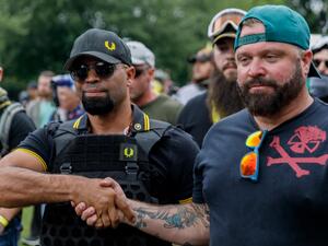In this file photo taken on August 17, 2019 leader of the Proud Boys Enrique Tarrio (L) and rally organizer Joe Biggs (R) congratulate each other as they return to the march starting-point over the Hawthorn Bridge as "The End Domestic Terrorism" rally at Tom McCall Waterfront Park concludes in Portland, Oregon. John Rudoff / AFP