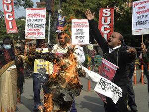 Activists and supporters of the Socialist Unity Centre of India (SUCI) shout slogans as they burn an effigy of Indian Prime Minister Narendra Modi during a protest rally supporting the ongoing farmers' protest against the central government's recent agricultural reforms, in Siliguri on January 31, 2021. DIPTENDU DUTTA / AFP