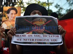 A Myanmar migrant holds up a poster with the image of Myanmar's Chief Senior General Min Aung Hlaing, commander-in-chief of the Myanmar armed forces, as they take part in a demonstration outside the Myanmar embassy in Bangkok on February 1, 2021, after Myanmar's military detained the country's de facto leader Aung San Suu Kyi and the country's president in a coup. Lillian SUWANRUMPHA / AFP