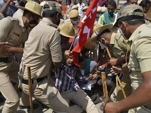 Police personnel detain protesting farmers belonging to the Karnataka Rajya Raitha Sangha (KRRS) gathered to take part and support the ongoing protests against the central government's recent agricultural reforms, in Tumkur district of Karnataka state on February 6, 2021. Manjunath Kiran / AFP