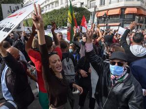 Tunisians gesture while shouting slogans against the government and police repression in the capital Tunis on February 6, 2021, as they demonstrate in commemoration of the 8th anniversary of the assassination of prominent leftist opposition leader Chokri Belaid. FETHI BELAID / AFP