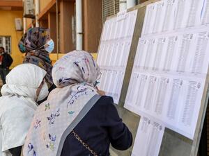 A mask-clad voter checks the electoral lists upon arriving to vote during an election for the Tripoli Municipal Council, in Libya's capital on February 6, 2021. Mahmud TURKIA / AFP