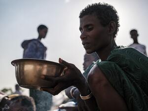 An Internally Displaced Person (IDP), fleeing from violence in the Metekel zone in Western Ethiopia, holds a bowl with food at a camp in Chagni, Ethiopia, on January 27, 2021. Inter-ethnic violence in Ethiopia's west -- concentrated in a lowland area known as Metekel -- predates a brutal three-month-old conflict farther north pitting Prime Minister Abiy Ahmed's government against the former ruling party of the Tigray region.  EDUARDO SOTERAS / AFP