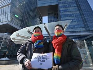 South Korean same-sex couple So Seong-wook (L) and Kim Yong-min (R) attend a press conference as they file a lawsuit against the National Health Insurance Service for their dependent family status, at the Seoul Administrative Court in Seoul on February 18, 2021. Jung Yeon-je / AFP