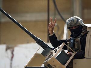 A member of the Iraqi force gestures during a search of the area in Tarmiyah, 35 kilometres (20 miles) north of Baghdad on February 20, 2021, following clashes with Islamic State group fighters. Iraqi security forces clashed with the Islamic State group north of Baghdad, leaving at least five jihadists and two security personnel dead. A joint force of army troops and state-sponsored tribal fighters raided an IS hideout in the leafy plains of Tarmiyah, according to a statement from the military. AFP