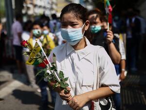 A protester places flowers as Myanmar migrants living in Thailand hold a demonstration remembering protesters killed while rallying against the military coup in their home country, and calling for the results of the 2020 Myanmar election to be upheld, outside the Indonesian ambassy in Bangkok on February 23, 2021. Jack TAYLOR / AFP