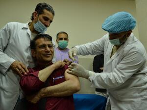 A medical worker (R) administers a dose of a Covid-19 coronavirus vaccine to a colleague at a hospital in Herat on February 24, 2021. Hoshang Hashimi / AFP