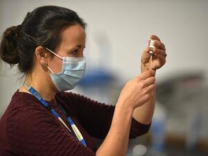 A doctor prepares to administer the Oxford-AstraZeneca COVID-19 vaccine at a temporary vaccination center in the Keepmoat Stadium in Doncaster, England. (AFP File Photo) 