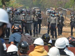 Riot police hold their firearms as they face off with protesters 