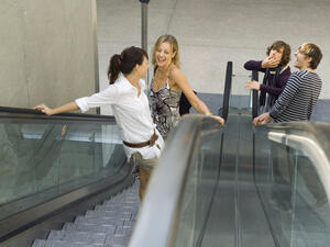 Men whistling at women on the escalator