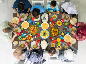 Family and friends gather at home to eat dinner