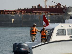 Egyptian coast guards patrol as a ship navigates the Suez Canal on March 30, 2021, a day after a cargo vessel was dislodged from its banks. Egyptian authorities have presented the freeing of the megaship, which was stuck for nearly a week and caused a 425- ship tailback to the north and south, as a major vindication of the country's engineering and salvage capabilities. Tarek WAJEH / AFP