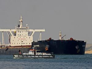 Egyptian coast guards patrol as a ship navigates the Suez Canal 