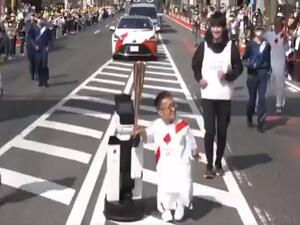 A robot helping to carry the Olympic torch (Image: Tokyo Olympics Twitter) 