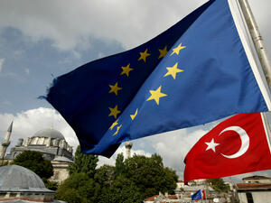 Turkish and EU flags seen in front a mosque in Istanbul